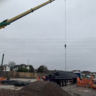 A Southdown delivery of 20+ metre beams to a construction project, being lifted off the extendable trailer A Southdown delivery of 20+ metre beams to a construction project, being lifted off the extendable trailer